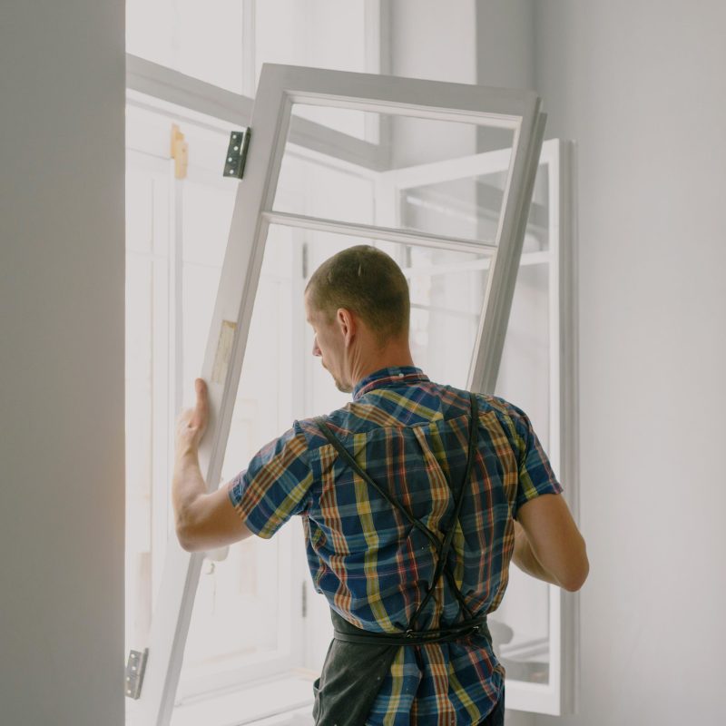 Fitter installing a new window frame in the façade of a home during a renovation