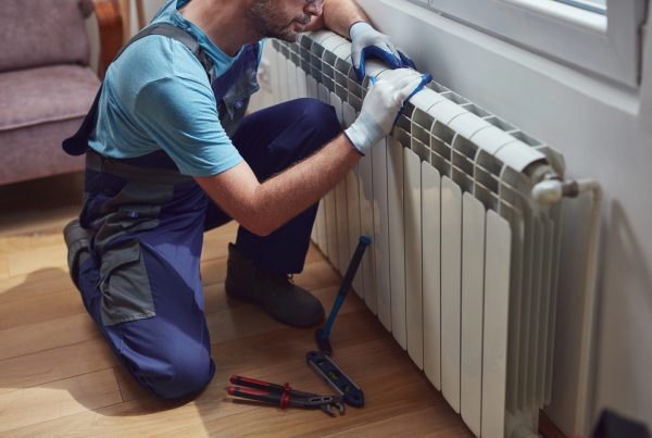 Installer checking the pressure of a central heating system before the start of the heating season