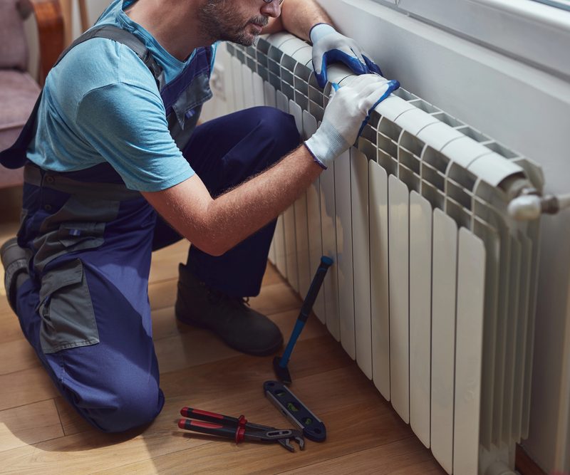 Installer checking the pressure of a central heating system before the start of the heating season