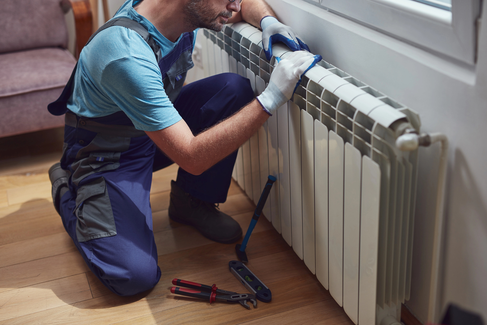 Installer checking the pressure of a central heating system before the start of the heating season
